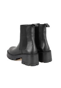 Schwarze Lederstiefeletten mit elastischen Seitenpanelen, robuster Gummisohle und Zuglaschen. Strukturiertes Finish und robuste Verarbeitung.