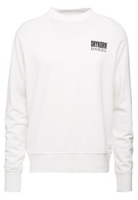 Sudadera blanca con cuello redondo y puños acanalados. Presenta un pequeño logo negro "DRYKORN" en el lado izquierdo del pecho. Textura de tela suave.