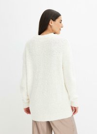 Cardigan bianco a maniche lunghe realizzato in tessuto a maglia testurizzato, con vestibilità rilassata e orlo posteriore leggermente più lungo.