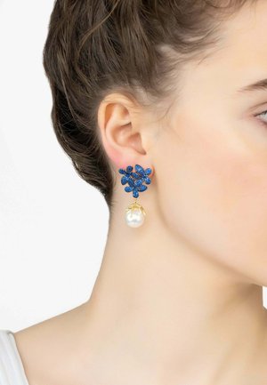 Orecchini floreali in pietra preziosa blu con goccia di perla, accentuati da hardware tono oro. Design elegante che pende vicino al lobo.