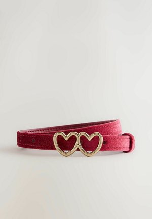 Cinturón de terciopelo rojo con dos hebillas entrelazadas en forma de corazón dorado sobre un fondo blanco liso.