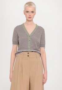 Striped short-sleeve top in light blue, burgundy, and olive, featuring a V-neck, button closure, and a relaxed fit. Beige high-waisted trousers.