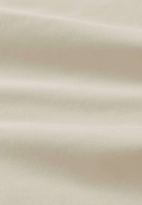 Tessuto di colore crema con una consistenza liscia e morbida, caratterizzato da pieghe delicate e un aspetto uniforme. Adatto per abbigliamento o rivestimenti.