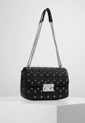 Zwarte gewatteerde handtas met zilveren ringen, voorzien van een rechthoekige zilveren sluiting en dubbele kettingbandjes. Het gestructureerde patroon versterkt het ontwerp.