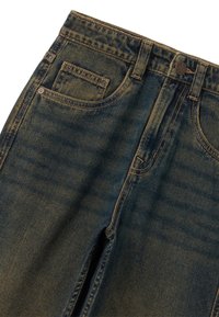 Jeans clásicos de mezclilla azul con un acabado ligeramente desgastado, con cinco bolsillos y costuras visibles. Incluye un cierre de botón metálico.