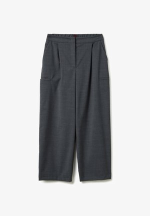 Pantaloni ampi grigio scuro con pieghe frontali, tasche laterali e un cinturino dritto, presentati in posizione piatta su uno sfondo bianco.