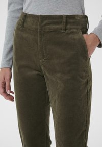 Grønne kordfløjl bukser med lige pasform, der har en tekstureret overflade, sidelommer og en taljebånd med bæltestropper.