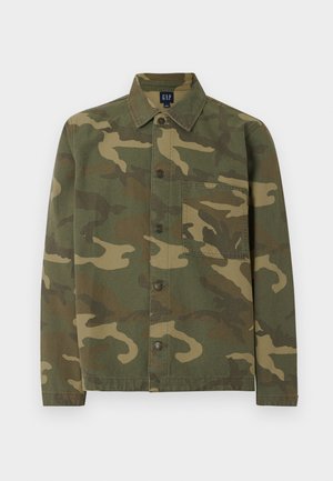 Cămașă cu mâneci lungi și nasturi, model camuflaj verde și maro, cu un buzunar pe piept, afișată plat pe un fundal alb.