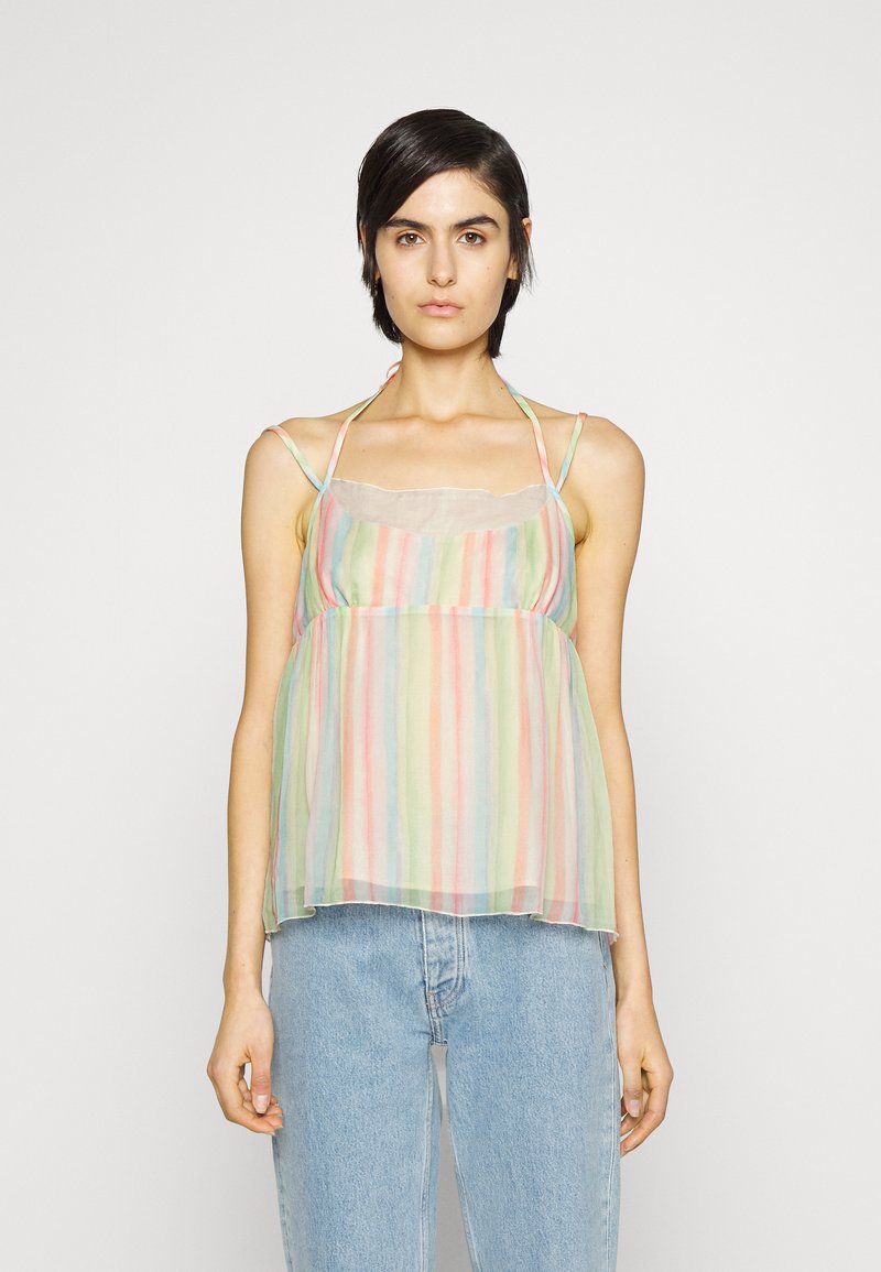 Débardeur transparent à rayures multicolores avec des bretelles spaghetti et un col en dentelle, associé à un jean en denim bleu clair.