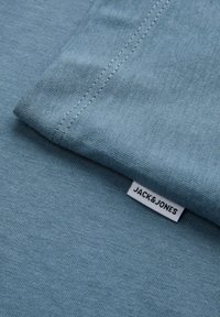 Short-sleeve, light blue T-shirt made of cotton; features a smooth texture and a visible label with "JACK&JONES" in black print.
