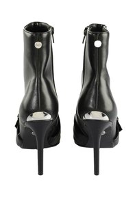 Melnas augstpapēžu potītes zābaki ar rāvējslēdzēju, gluda ādas virsma un spīdīgi sudraba akcenti uz papēža un aizmugures.