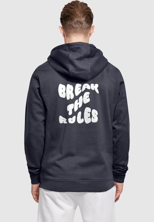 Marineblauer Hoodie mit einem großen, flauschigen weißen Schriftzug auf dem Rücken, der "BREAK THE RULES" lautet; mit einer Kapuze mit Kordelzug und gerippten Bündchen.