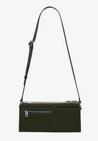 Grüne Leder-Umhängetasche mit verstellbarem Riemen, ausgestattet mit einer Reißverschlusstasche, rechteckiger Form und glatter Textur. Silberne Hardware-Akzente.