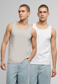 Two tank tops, one gray and one white, both made of cotton. They feature a classic ribbed design with rounded necklines and regular fit.
