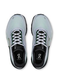 Chaussures de sport grises et noires avec une tige en mesh, des accents verts et des lacets blancs. Dotées d'une semelle coussinée et d'une semelle intérieure de marque.