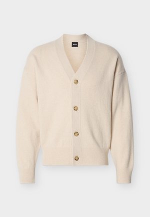 Cardigan beige en maille avec col en V, manches longues, poignets et ourlet côtelés, et quatre boutons marron clair sur le devant.