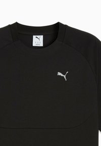 Sort atletisk skjorte med rund hals og et reflekterende sølvfarvet Puma-logo på brystet. Enkel, moderne design med fokus på funktionalitet.