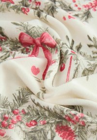 Kreemivärvi kangas, millel on lillemuster, kus on punased marjad, rohelised lehed ja roosa pael. Materjal näeb välja pehme ja tekstuuriga.