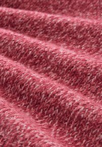 Strukturiertes Gewebe in unterschiedlichen Rosatönen mit einem gewebten Muster und weißen Sprenkeln, das ein weiches, gemütliches Aussehen erzeugt.