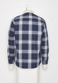 Marinblå rutig skjorta med vita och grå rutmönster, långa ärmar med knappmanchetter och en mjuk krage.