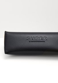 Custodia in pelle nera con una texture liscia, caratterizzata da un marchio in rilievo "SUPER", forma rettangolare e dettagli di cucitura sottili.