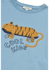 Ανοιχτό μπλε βαμβακερό μπλουζάκι με κίτρινη και μαύρη ριγέ τίγρη πάνω σε σκέιτμπορντ, με το κείμενο «COOL KIDS» σε παιχνιδιάρικη γραμματοσειρά.