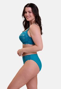 Sostenedor de encaje en color teal con un patrón floral transparente y bragas de tiro alto a juego. Material suave, tirantes ajustables y bordes decorativos.