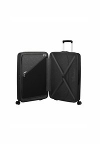 Valigia nera con ruote, dotata di un rivestimento esterno testurizzato, doppia cerniera, tasca interna in rete e una tracolla regolabile per fissare il contenuto.