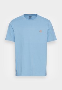 T-shirt de algodão azul claro com decote redondo, mangas curtas e um pequeno logótipo multicolorido no lado esquerdo do peito. Textura suave, corte regular.