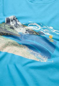 Mėlynos spalvos medvilninis marškinėliai su grafiniu dizainu, vaizduojančiu pakrantės sceną su uolomis, bangomis ir saule, atlikti pastelinių spalvų ir drąsių potėpių.