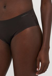 Zwarte bikinionderkant met een gladde stof, een mid-rise snit en subtiele branding op de tailleband. Naadloos ontwerp voor comfort.