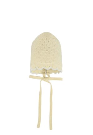 Bonnet de bébé beige tricoté avec des bords festonnés et deux longues lanières pendantes conçues pour se fixer sous le menton.