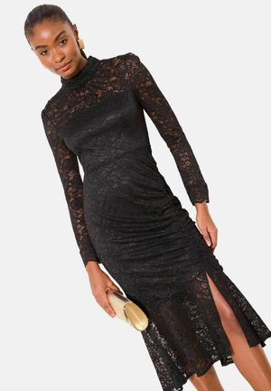 Schwarzes Spitzenkleid mit langen Ärmeln, gerafften Details und seitlichem Schlitz. Es verfügt über einen hohen Ausschnitt und ein optisch strukturiertes Blumenmuster.