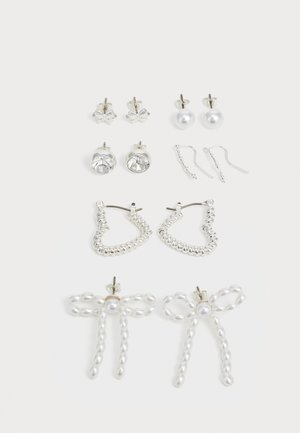 Set of earrings featuring various designs: silver studs, pearl drops, crystal accents, and beaded hoops with bow details.