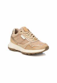 Sneaker atletico beige con una toma superiore testurizzata, chiusura con lacci e collo della caviglia imbottito. I dettagli includono hardware dorato e una suola intermedia bianca.