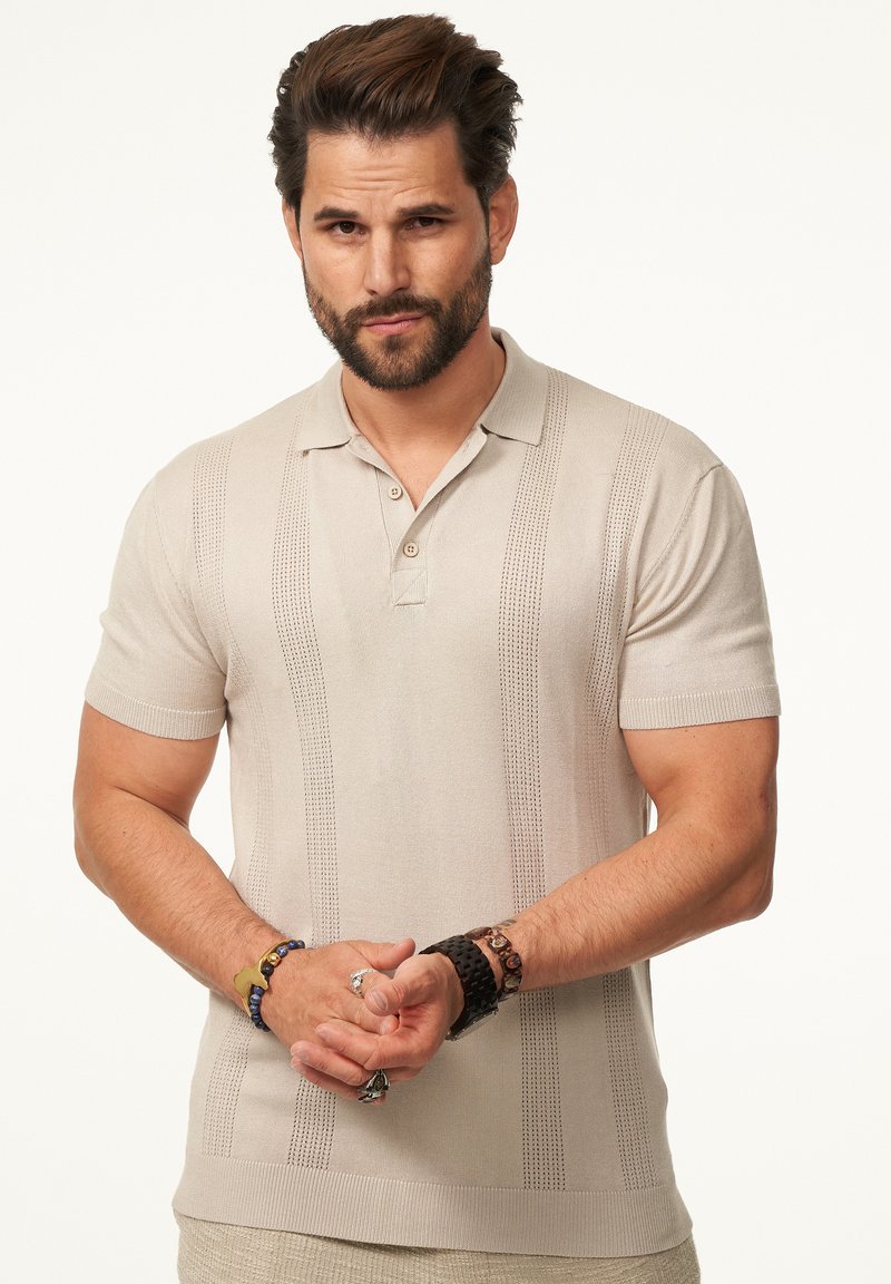 Beige Poloshirt mit kurzen Ärmeln, vertikaler Strickstruktur und halbem Knopfverschluss, mit taillierter Passform und gerippten Armabschlüssen.