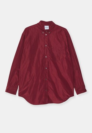 Burgundy, long-sleeve shirt made of smooth fabric. Features a button-down collar, front pocket, and subtle sheen. Buttons are silver-colored.