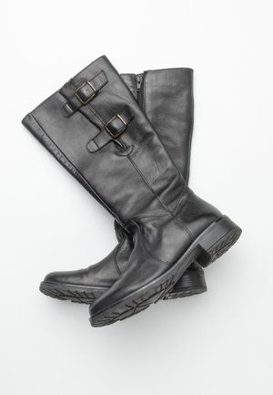 Botas de cuero negro hasta la rodilla con dos Hebillas decorativas, una textura suave y una suela con relieve. Cuenta con una cremallera lateral para facilitar su uso.