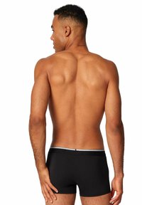 Boxer da uomo neri con elastico grigio, tessuto elasticizzato, design aderente e motivo semplice. Il modello è visto di spalle.