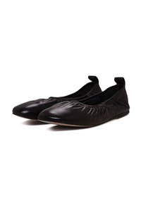 Ballerine in pelle nera con dettaglio arricciato lungo i bordi, texture morbida e suola piatta. Presentano un retro basso e un design minimalista.