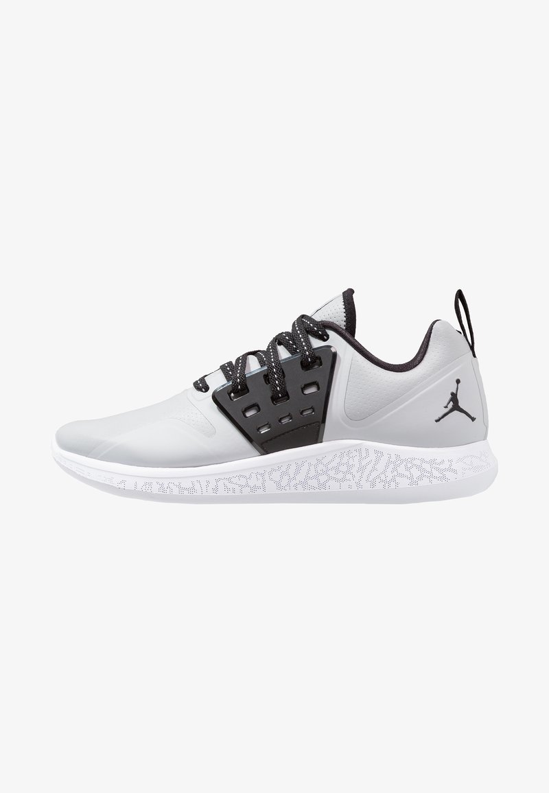 Baskets de sport basses blanches et grises avec des lacets noirs, une cage à lacets noire et un logo Jumpman noir sur le talon, sur une semelle blanche à motifs.