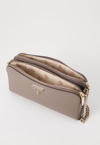 Bruine neplederen portemonnee met dubbele ritscompartimenten, gouden hardware en een gestreepte binnenkant met logo's. Kettinghengsel bevestigd.