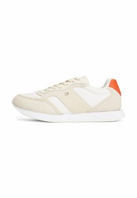 Scarpa sportiva beige con dettagli bianchi e un vivace tab del tallone arancione. Realizzata in pelle liscia e suede, presenta una suola testurizzata.