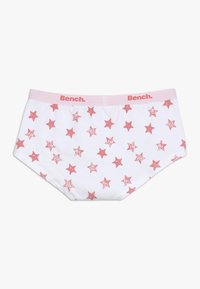 Sous-vêtements blancs avec une taille rose portant le nom de la marque. Le tissu est décoré de motifs d'étoiles rouges dispersés et d'une texture douce.