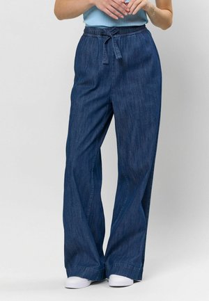Pantaloni din denim cu picioare largi, de culoare albastru închis, având o talie elastică cu un șnur în față, textură netedă și o croială lejeră.