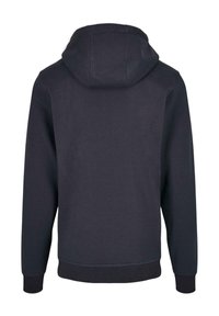 Hoodie i mörk marinblå, tillverkad av mjuk bomullsblandning. Har muddar och nederkant i matchande ribbat material, slät textur och minimalistisk design.