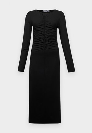 Long-sleeved black dress with a gathered front, featuring a fitted silhouette and smooth fabric, extending to the ankles. Simple, monochromatic design.