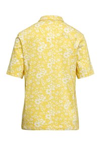 Kurzärmliges Hemd aus gelbem Stoff mit weißen Blumenmustern. Klassischer Kragen, lockere Passform, strukturierte Oberfläche.