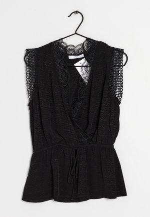 Blouse noire sans manches avec bordure en dentelle aux épaules et à l'encolure, col en V, taille froncée, suspendue sur un cintre noir devant un fond blanc.