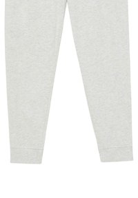 Helle graue Jogginghosen aus weichem Baumwollstoff. Mit schmal zulaufenden Beinen, elastischen Bündchen und einer glatten Textur ohne sichtbare Muster.